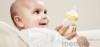 Ребенок держит бутылку с соской для грудного молока Medela Calma 2012 